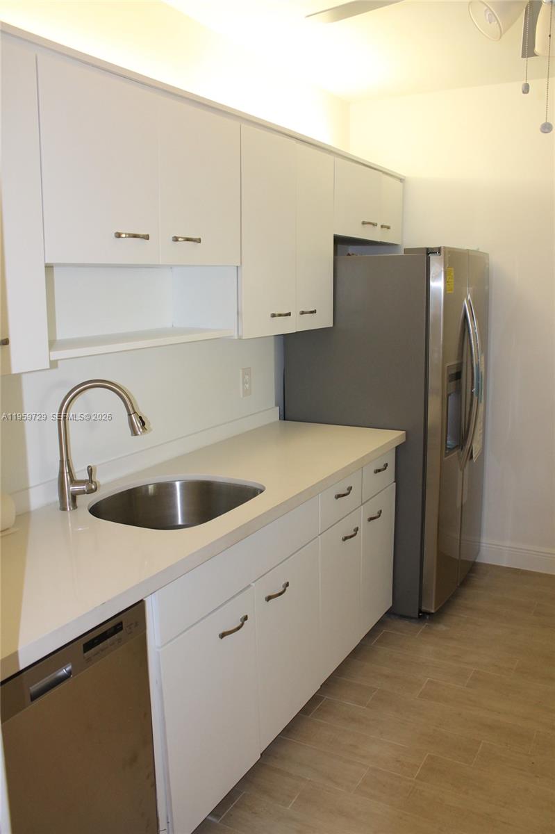 A kitchen features white cabinets, a stainless steel sink, and stainless steel appliances — 181 Crandon Blvd # 308, Key Biscayne FL 33149, KEY BISCAYNE, FL