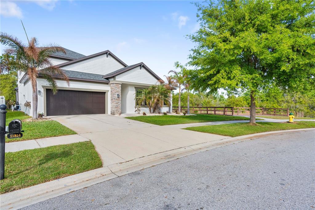A single-story house with a white exterior, stone accents, and a two-car garage — 11814 CROSS VINE DRIVE, RIVERVIEW, FL