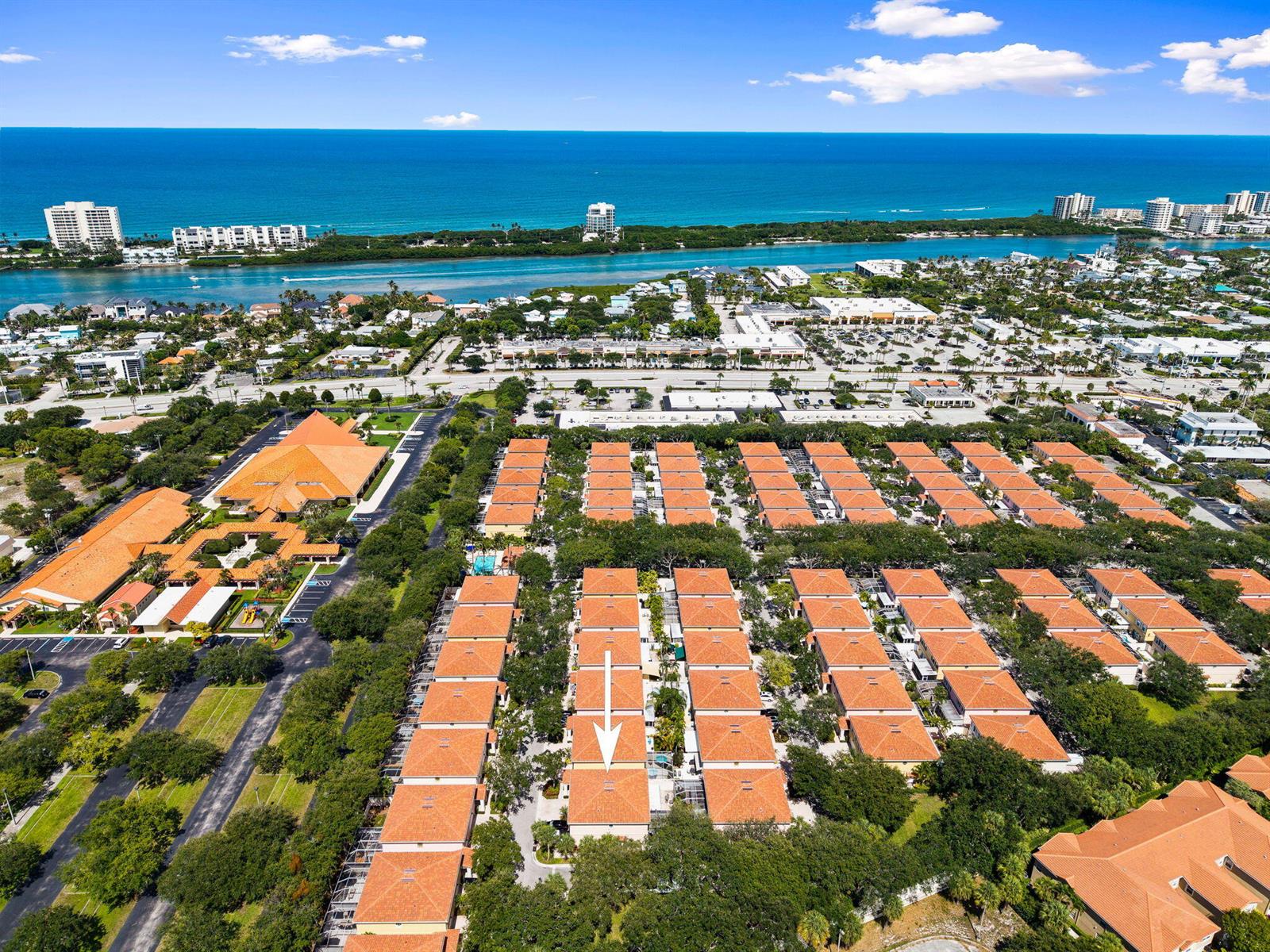 An aerial view shows a residential community with orange-tiled roofs near a coastal waterway — 48 Live Oak Circle, Jupiter FL 33469, JUPITER, FL