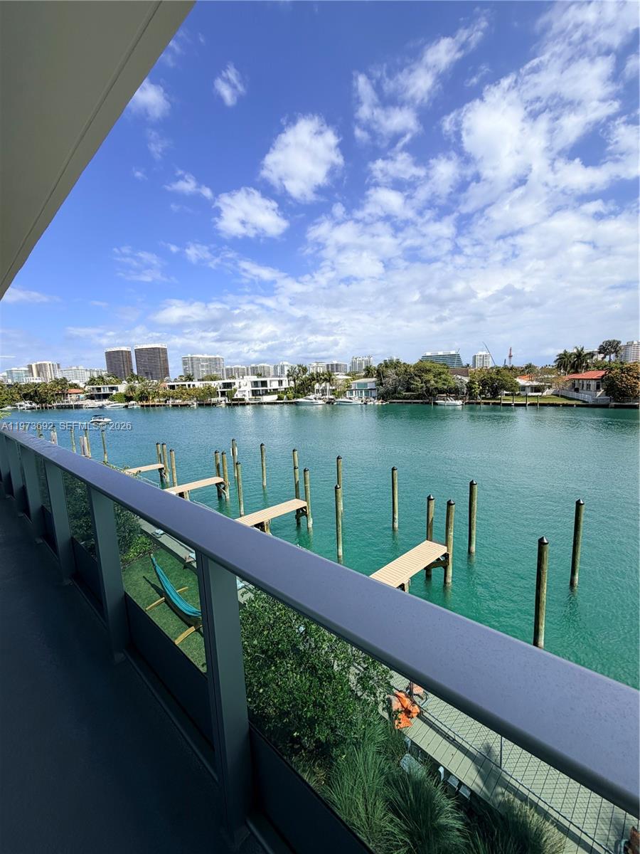 A balcony view overlooking a calm canal with wooden pilings and distant buildings — 9221 E Bay Harbor Dr # 307, Bay Harbor Islands FL 33154, BAY HARBOR ISLANDS, FL