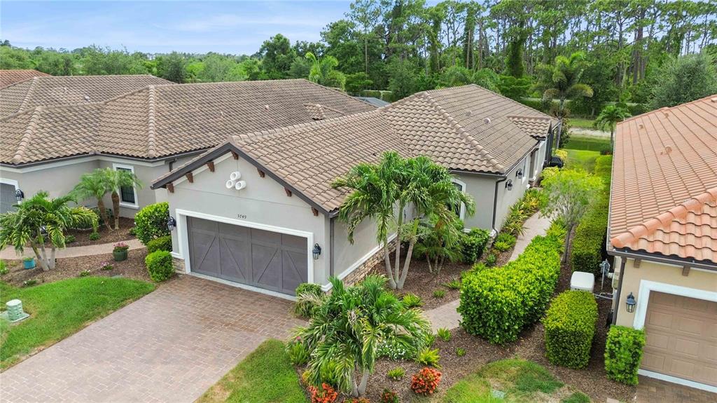 An aerial view of a suburban house with a tiled roof and a paved driveway — 5749 SEMOLINO STREET, NOKOMIS, FL