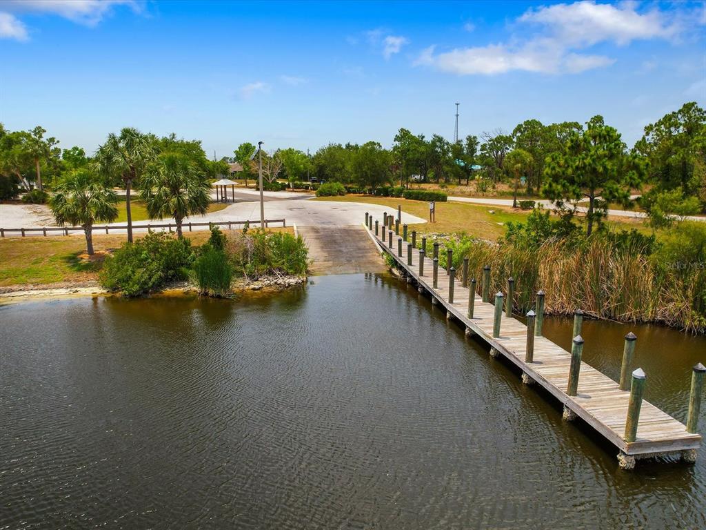 An aerial view of a wooden boat dock extending into a lake near a ramp — 14464 EDNA CIR, PORT CHARLOTTE, FL