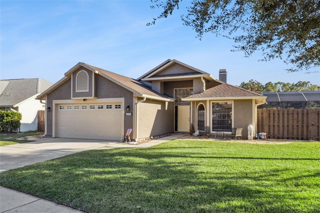 A single-story house with a tan stucco exterior, a two-car garage, and a front lawn — 5526 DEEPDALE DRIVE, ORLANDO, FL