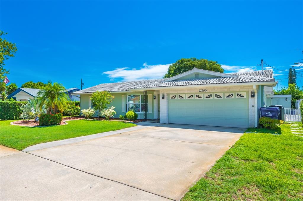 A single-story house with a light green exterior, a two-car garage, and a concrete driveway — 11290 142ND STREET, LARGO, FL