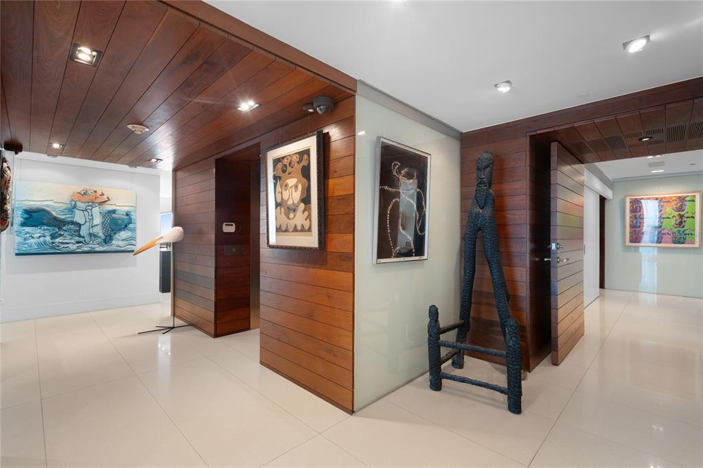 A modern, high-ceilinged living room with floor-to-ceiling windows, ocean views, and a large sectional sofa — 1052 ASHFORD AVENUE UNIT PH-18, SAN JUAN, PR