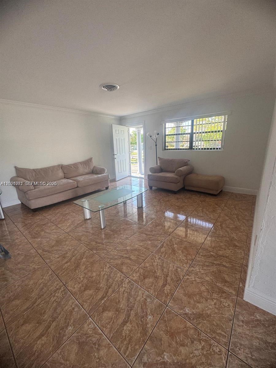 A living room features beige furniture, a glass coffee table, and brown tile flooring — 2801 NW 183rd St, Miami Gardens FL 33056, MIAMI GARDENS, FL