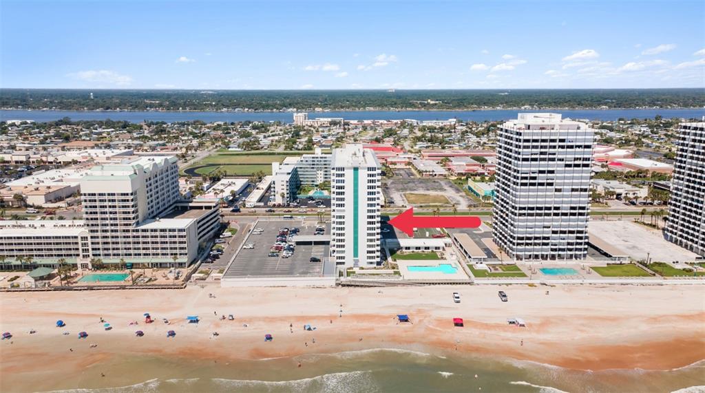 An aerial view shows several high-rise beachfront buildings along a sandy coastline — 2800 N ATLANTIC AVENUE UNIT 715, DAYTONA BEACH, FL