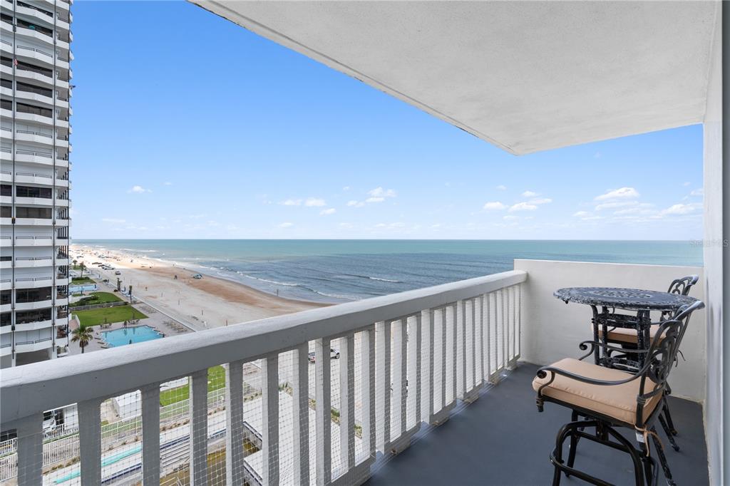 A balcony with patio furniture overlooks a sandy beach and the ocean — 2800 N ATLANTIC AVENUE UNIT 715, DAYTONA BEACH, FL