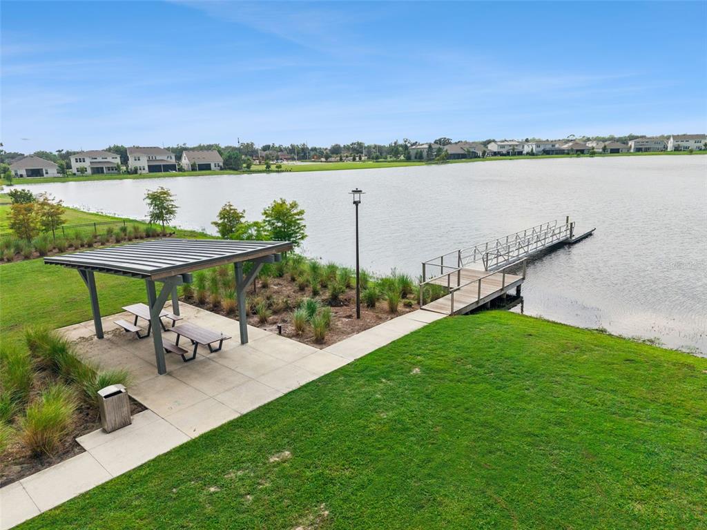 A lakeside park area features a covered picnic pavilion, a concrete walkway, and a wooden dock — 19053 BLUELEAF STREET, ORLANDO, FL