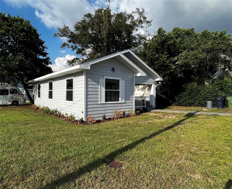 A light gray, single-story house with white trim and a small front porch — 402 E EMMA STREET, TAMPA, FL