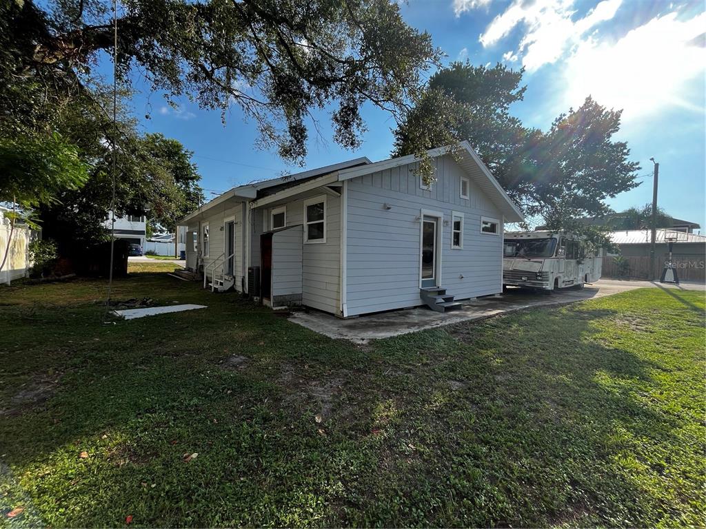 The exterior of a light blue house with a concrete patio and a parked RV — 402 E EMMA STREET, TAMPA, FL