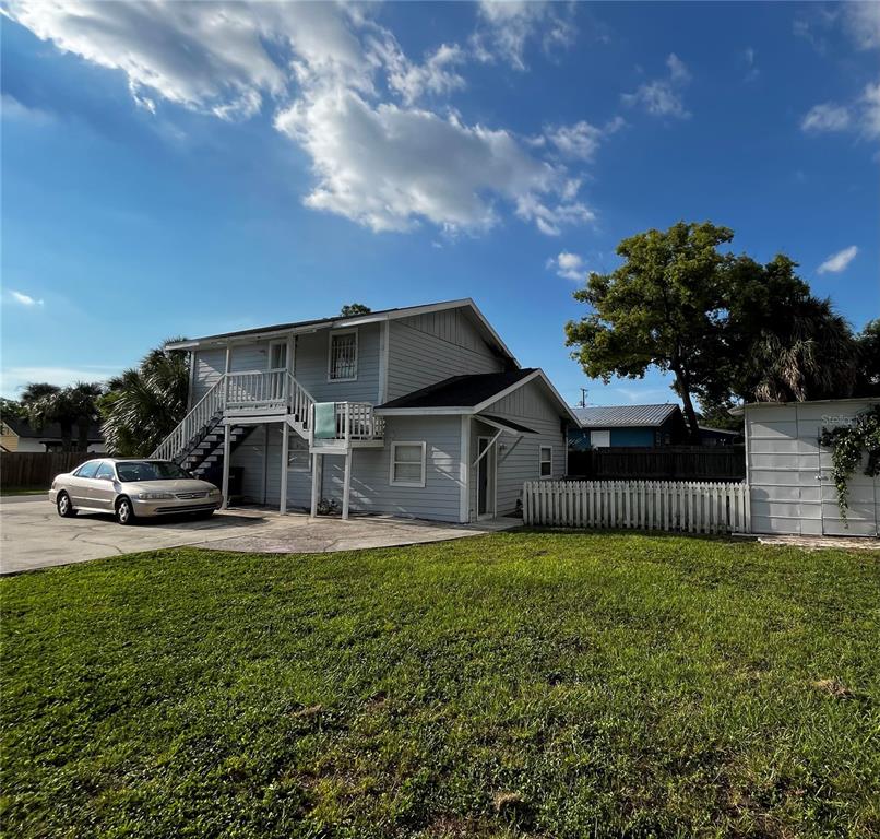 A two-story light gray house with an exterior staircase and a detached metal shed — 402 E EMMA STREET, TAMPA, FL