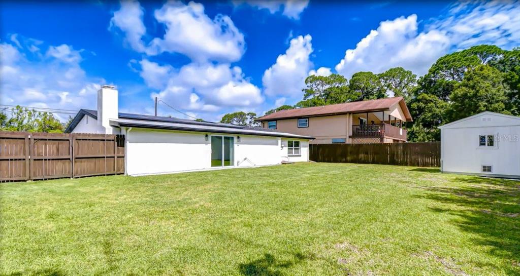A single-story house with a white stucco exterior, a covered porch, and a concrete driveway — 6291 63RD STREET N, PINELLAS PARK, FL