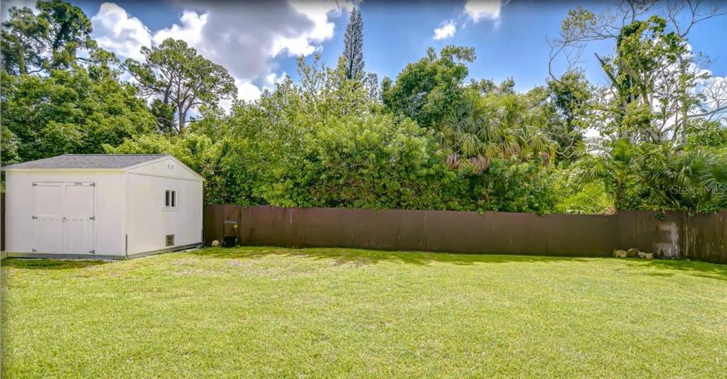 A single-story house with a cream-colored exterior, a covered porch, and a concrete driveway — 6291 63RD STREET N, PINELLAS PARK, FL