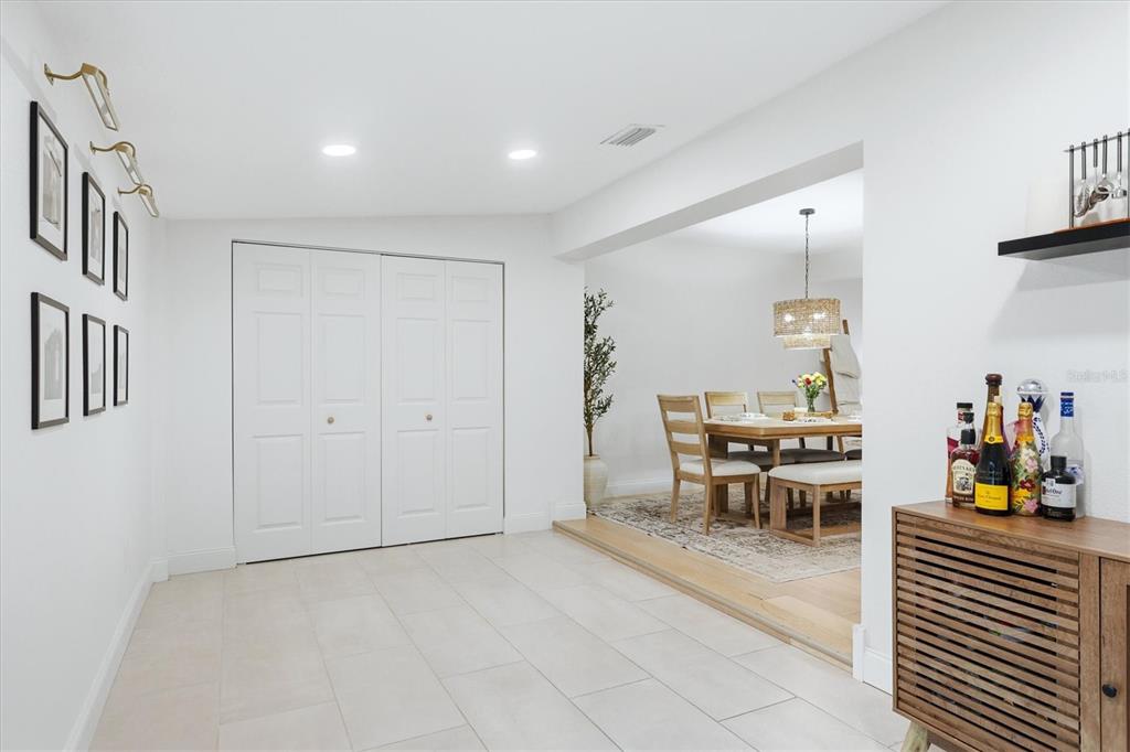 A tiled room with a closet leads to a dining area with wood flooring — 6291 63RD STREET N, PINELLAS PARK, FL