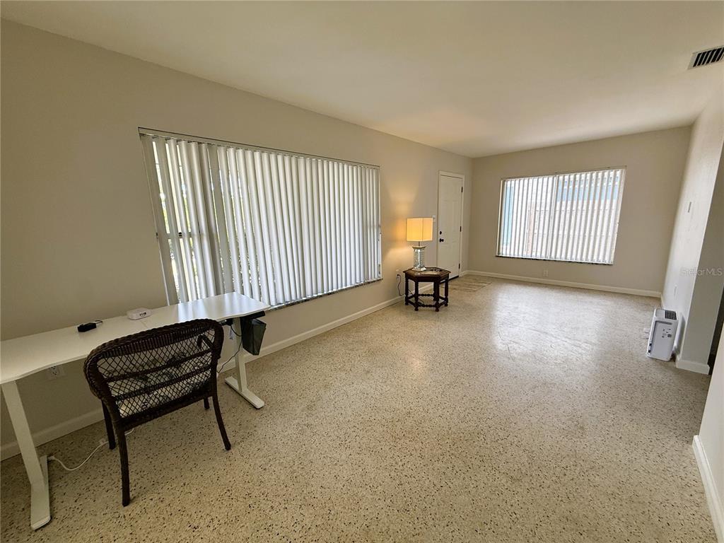 A room with light-colored walls, terrazzo flooring, two windows with vertical blinds, and a desk — 14017 W PARSLEY DRIVE, MADEIRA BEACH, FL