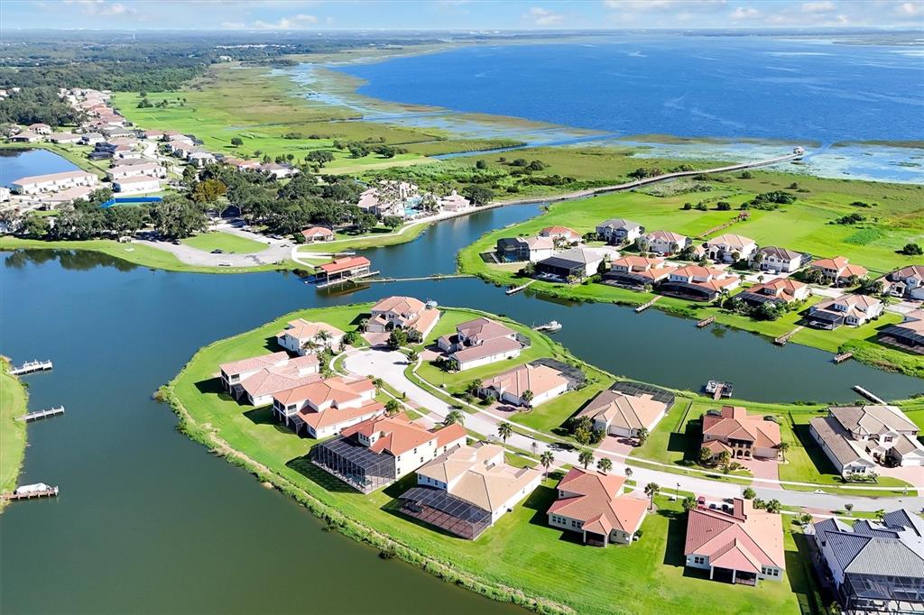 An aerial view of a waterfront residential neighborhood with houses, canals, and a large lake — 870 SPINNAKER WAY, KISSIMMEE, FL