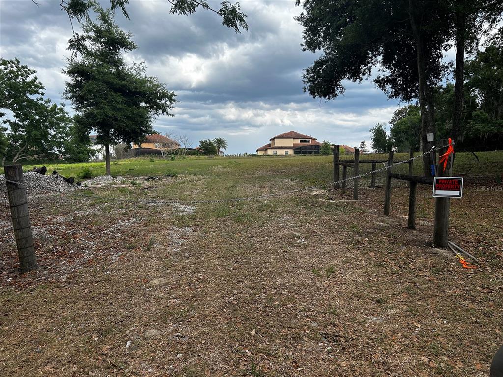 A grassy, vacant lot is enclosed by a wire fence with a private property sign — 0 TOMATO HILL ROAD, LEESBURG, FL