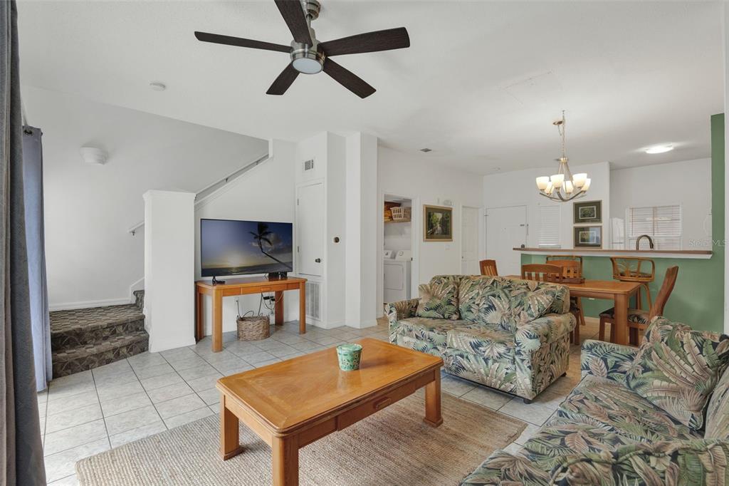 A living room with tile floors, tropical-print furniture, a wooden coffee table, and a ceiling fan — 1086 PARK RIDGE CIRCLE, KISSIMMEE, FL