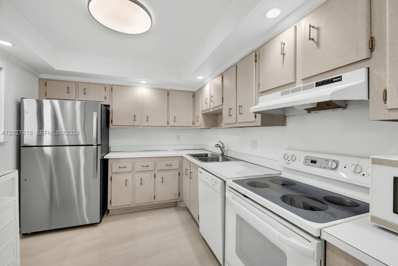A kitchen features light-colored cabinetry, stainless steel appliances, and white countertops — 200 Ocean Trail Way # 1108, Jupiter FL 33477, JUPITER, FL
