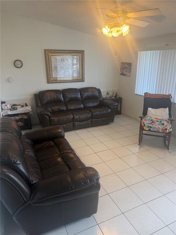 A living room features white tile floors, two dark leather sofas, and a wooden rocking chair — 1304 DONWOODS LANE, ROYAL PALM BEACH, FL