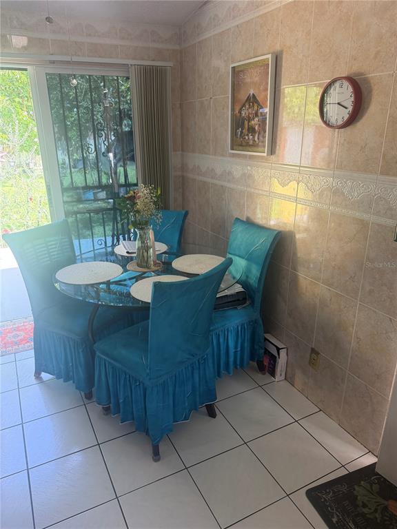 A dining area features a glass-topped table with four teal chairs and tiled walls — 1304 DONWOODS LANE, ROYAL PALM BEACH, FL