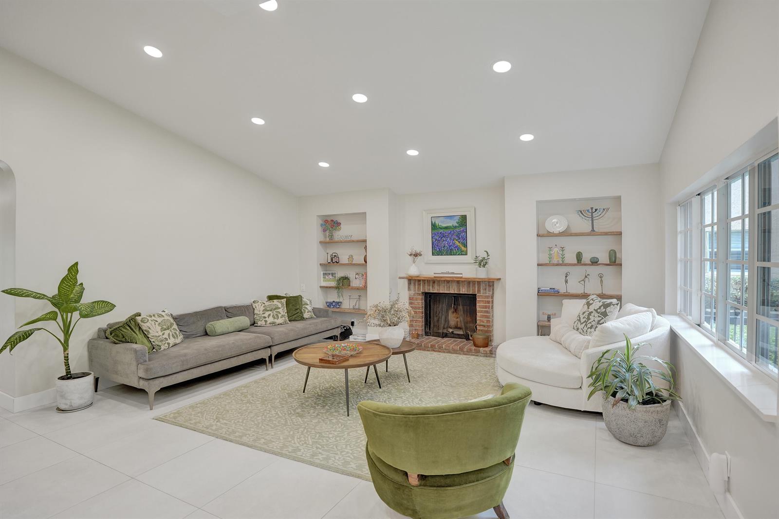 A living room features a brick fireplace, built-in shelving, a gray sofa, and white tile floors — 12213 Melissa Way, Cooper City FL 33026, COOPER CITY, FL