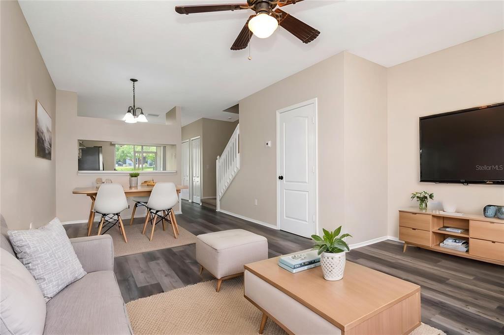 A living room and dining area with wood-look flooring, a ceiling fan, and white walls — 2439 LAKE WOODBERRY CIRCLE, BRANDON, FL