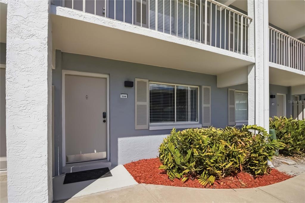 A grassy park area overlooks a sandy beach, a wooden pier, and tall apartment buildings — 127 OYSTER BAY CIRCLE UNIT 110, ALTAMONTE SPRINGS, FL