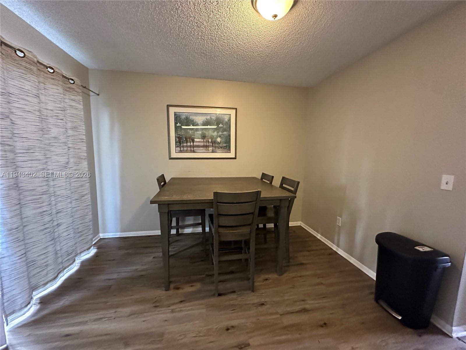 A dining area features a square wooden table with four chairs on wood-look flooring — 6060 Village Cir, Orlando FL 32822, ORLANDO, FL