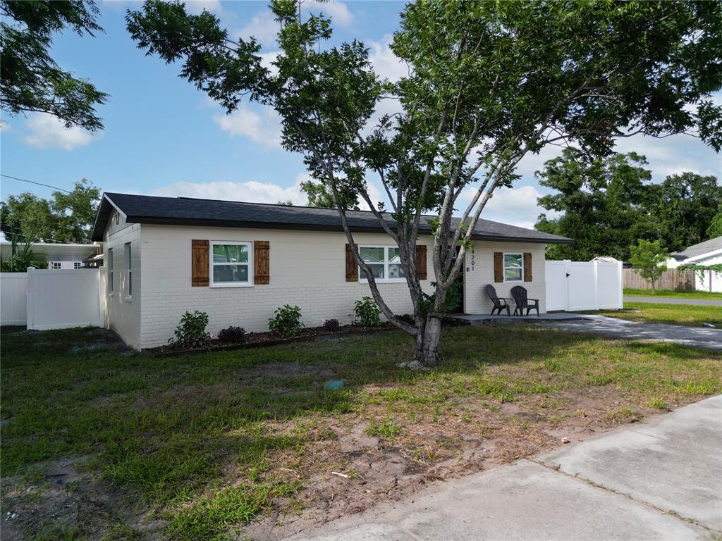 A single-story house with a light-colored brick exterior, dark roof, and wooden window shutters — 4201 55TH AVENUE N, ST PETERSBURG, FL