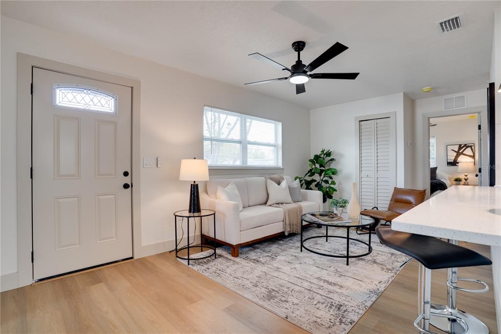 A living room features a white sofa, a round coffee table, and a ceiling fan — 4201 55TH AVENUE N, ST PETERSBURG, FL