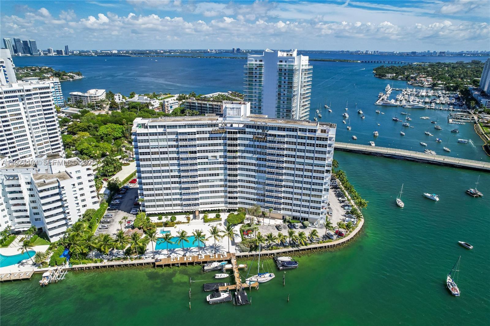 An aerial view shows a large waterfront apartment building with a pool and boat docks — 20 E Island Ave # 1415, Miami Beach FL 33139, MIAMI BEACH, FL