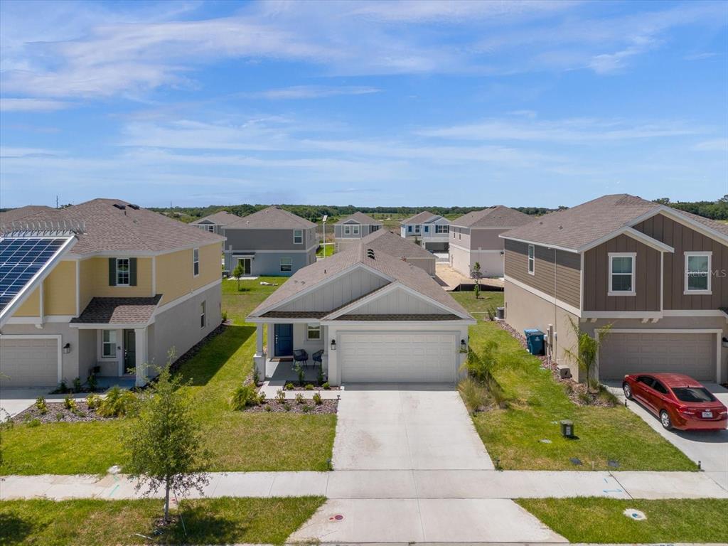 An aerial view shows a suburban street with three single-family homes and a red car — 622 BELL PRAIRIE CIRCLE, LAKE WALES, FL