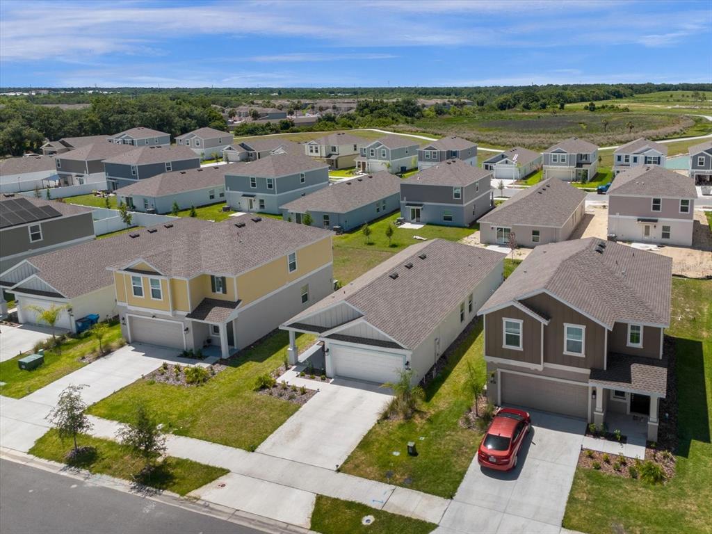 An aerial view shows a suburban neighborhood with several detached single-family homes and paved driveways — 622 BELL PRAIRIE CIRCLE, LAKE WALES, FL