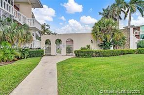 A concrete walkway leads to a gated entrance in a low-rise residential building exterior — 141 NE 10th Ave # 29B, Hallandale Beach FL 33009, HALLANDALE BEACH, FL