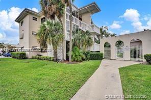 A multi-story apartment building with a white exterior, palm trees, and a paved walkway — 141 NE 10th Ave # 29B, Hallandale Beach FL 33009, HALLANDALE BEACH, FL
