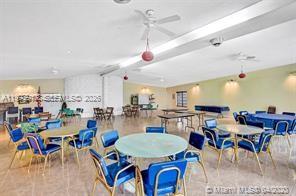 A large community room features round tables with blue chairs and ceiling fans — 141 NE 10th Ave # 29B, Hallandale Beach FL 33009, HALLANDALE BEACH, FL
