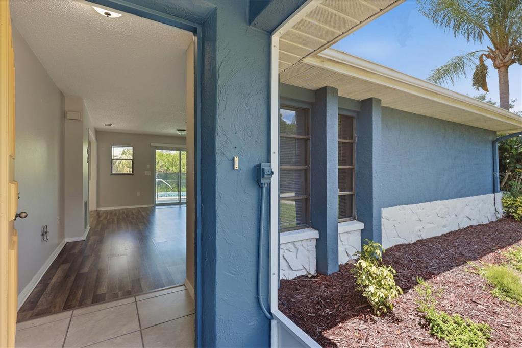 A view from a tiled entryway looking into a living area with wood-look flooring — 4850 BRICKELL DRIVE, NORTH PORT, FL