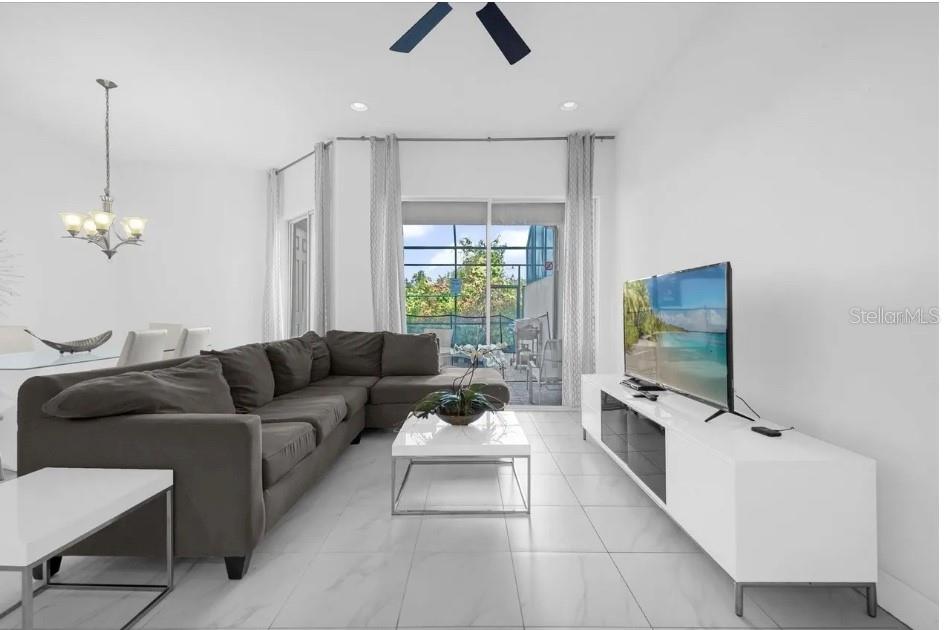 A living room with a gray sectional sofa, white coffee table, and a television console — 450 CAPTIVA DRIVE, DAVENPORT, FL