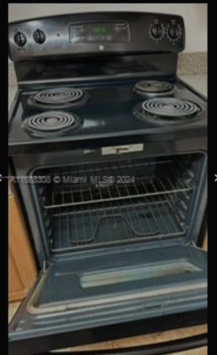 A black electric range with a glass-front oven door sits in a kitchen — 2952 NW 55th Ave # 2D, Lauderhill FL 33313, LAUDERHILL, FL