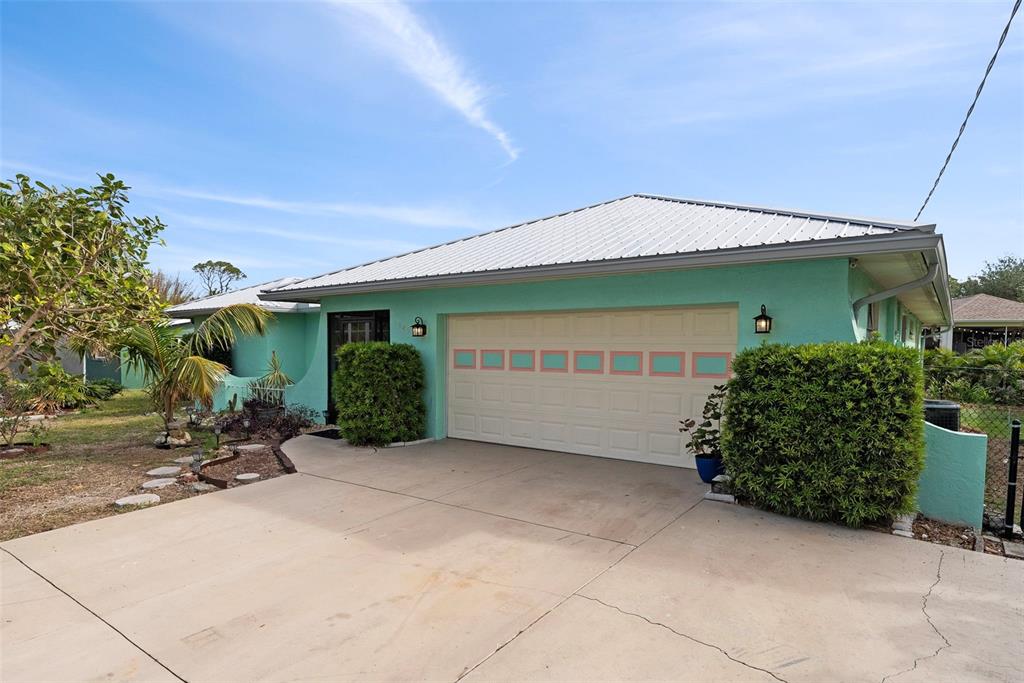 An aerial view shows a house with a metal roof, a pool, and a backyard — 1845 EDISON DRIVE, ENGLEWOOD, FL