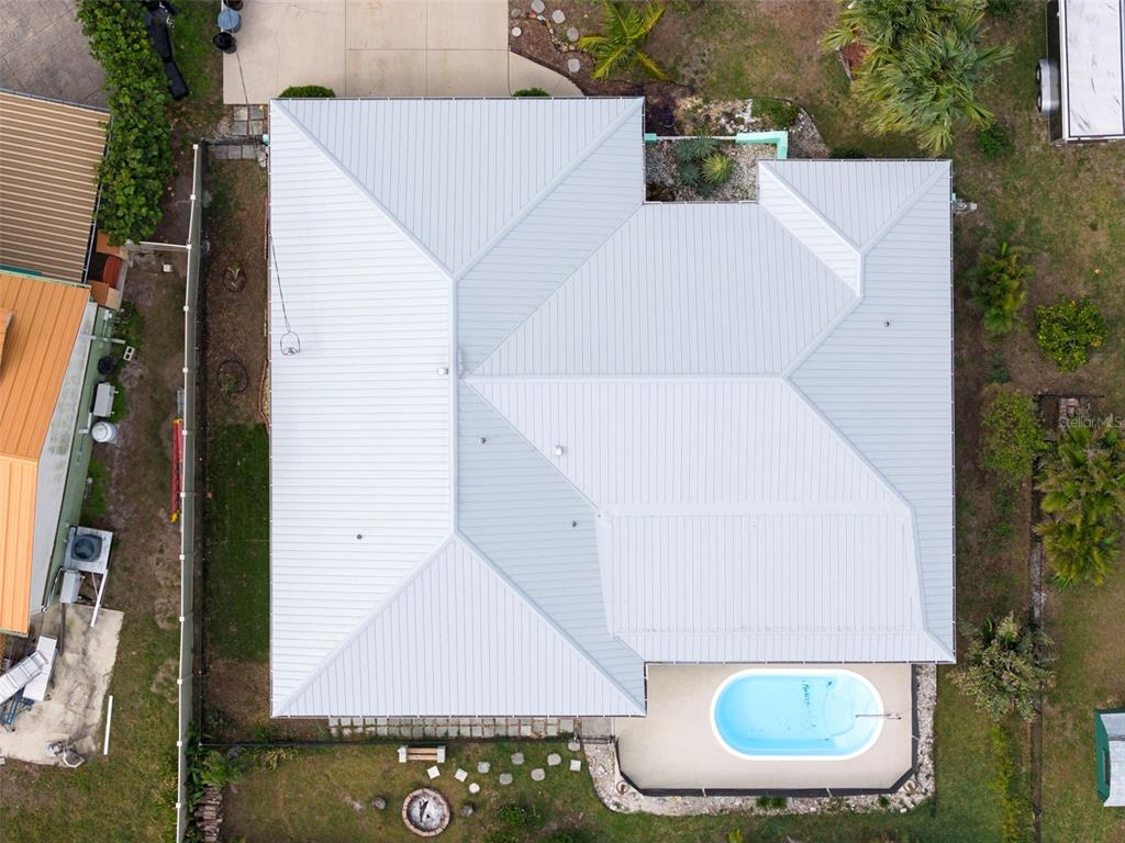 A small swimming pool sits on a patio next to a screened-in porch — 1845 EDISON DRIVE, ENGLEWOOD, FL