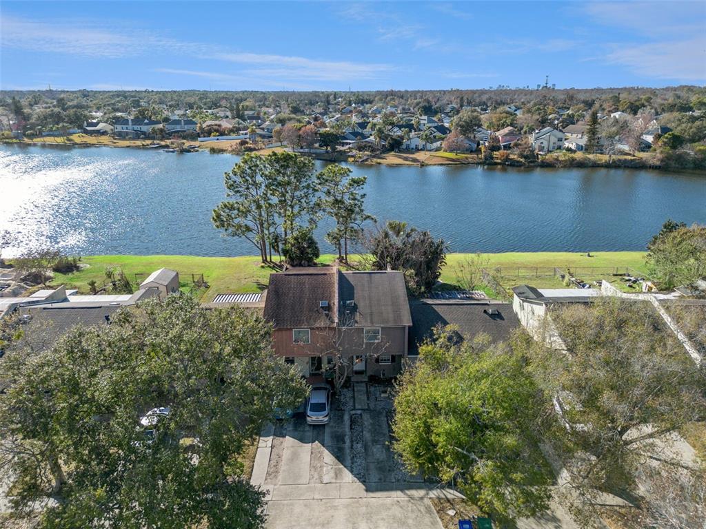 An aerial view shows a two-story duplex house with a driveway facing a lake — 2538 RIO PINAR LAKES BOULEVARD, ORLANDO, FL