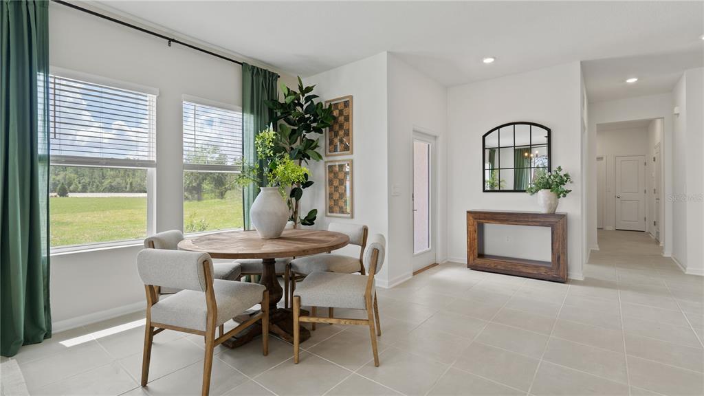 A dining area features a round wooden table, four chairs, and a console table — 4286 ST THOMAS WAY, KISSIMMEE, FL