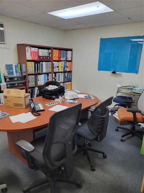 An office space features a large oval desk, rolling chairs, a bookshelf, and a whiteboard — 232 N MAIN STREET, BUSHNELL, FL