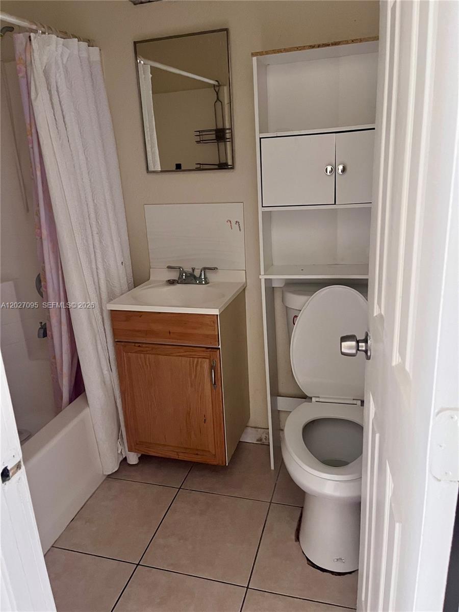 A small bathroom features a vanity, a toilet with an over-the-toilet storage unit, and shower — 109 NW 14th Way # 3, Dania Beach FL 33004, DANIA BEACH, FL