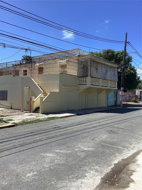 A two-story, light-yellow concrete building with an exterior staircase and metal security grilles — Calle Union PLAYA PUERTO REAL UNIT 454, FAJARDO, PR