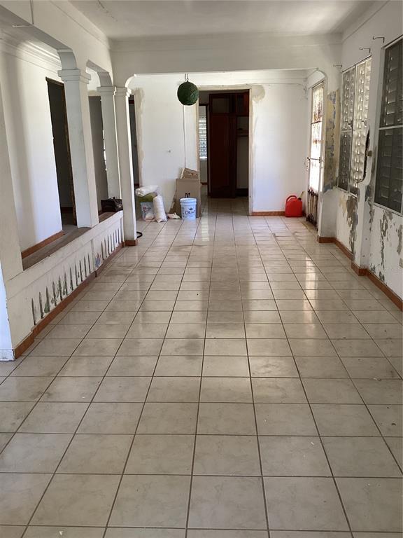 An interior view of a long, tiled room with white walls, arched columns, and peeling paint — Calle Union PLAYA PUERTO REAL UNIT 454, FAJARDO, PR