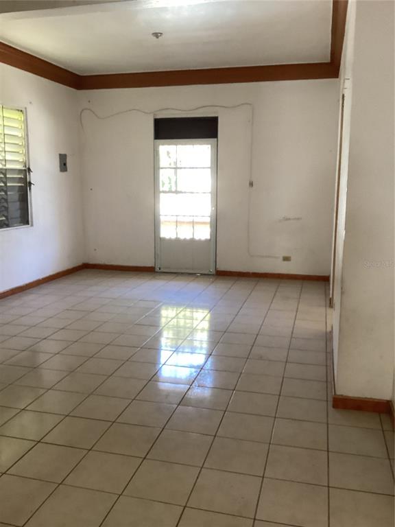 An empty room features white walls, a tiled floor, and a glass-paneled door — Calle Union PLAYA PUERTO REAL UNIT 454, FAJARDO, PR